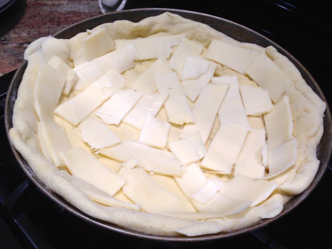 After baking crust for 5 minutes, top with mozzarella slices...