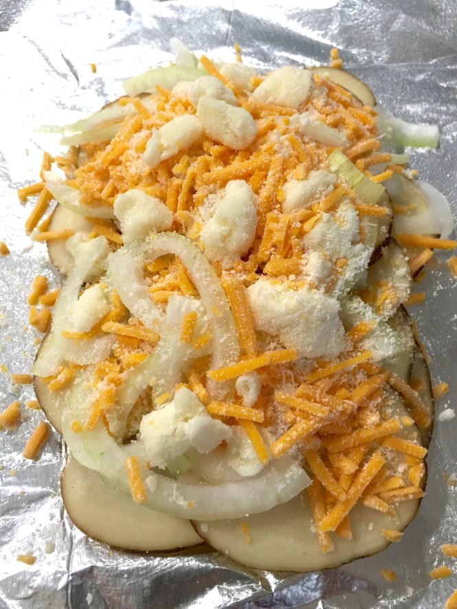 Top the potatoes and onions with the cheeses: cheddar, mozzarella and parmesan